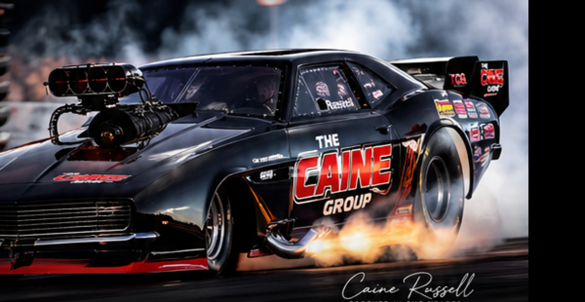 The Caine Group Funny Car launching through smoke and fire